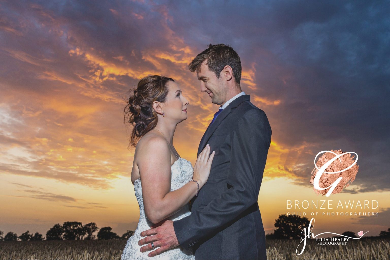 bride-and-groom-in-crop-field-looking-at-each-other-during-sunset