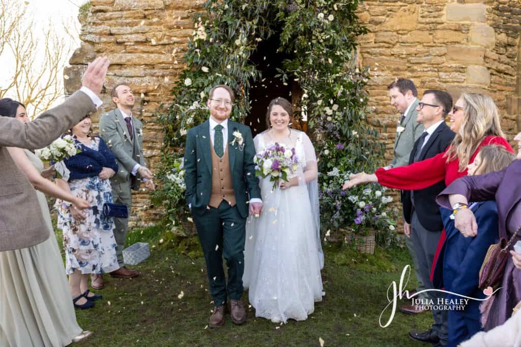 Bride and groom showered with confetti at wedding.