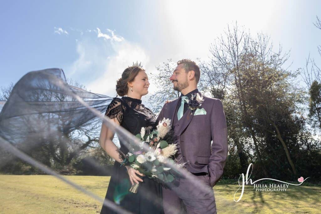 Couple in elegant attire under sunny sky