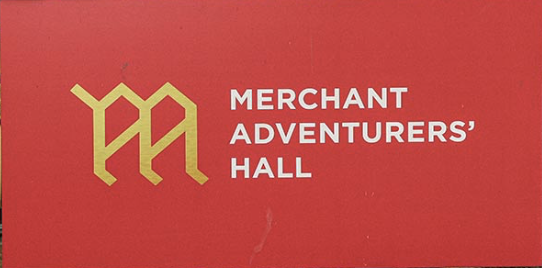 Merchant Adventurers’ Hall sign on red background